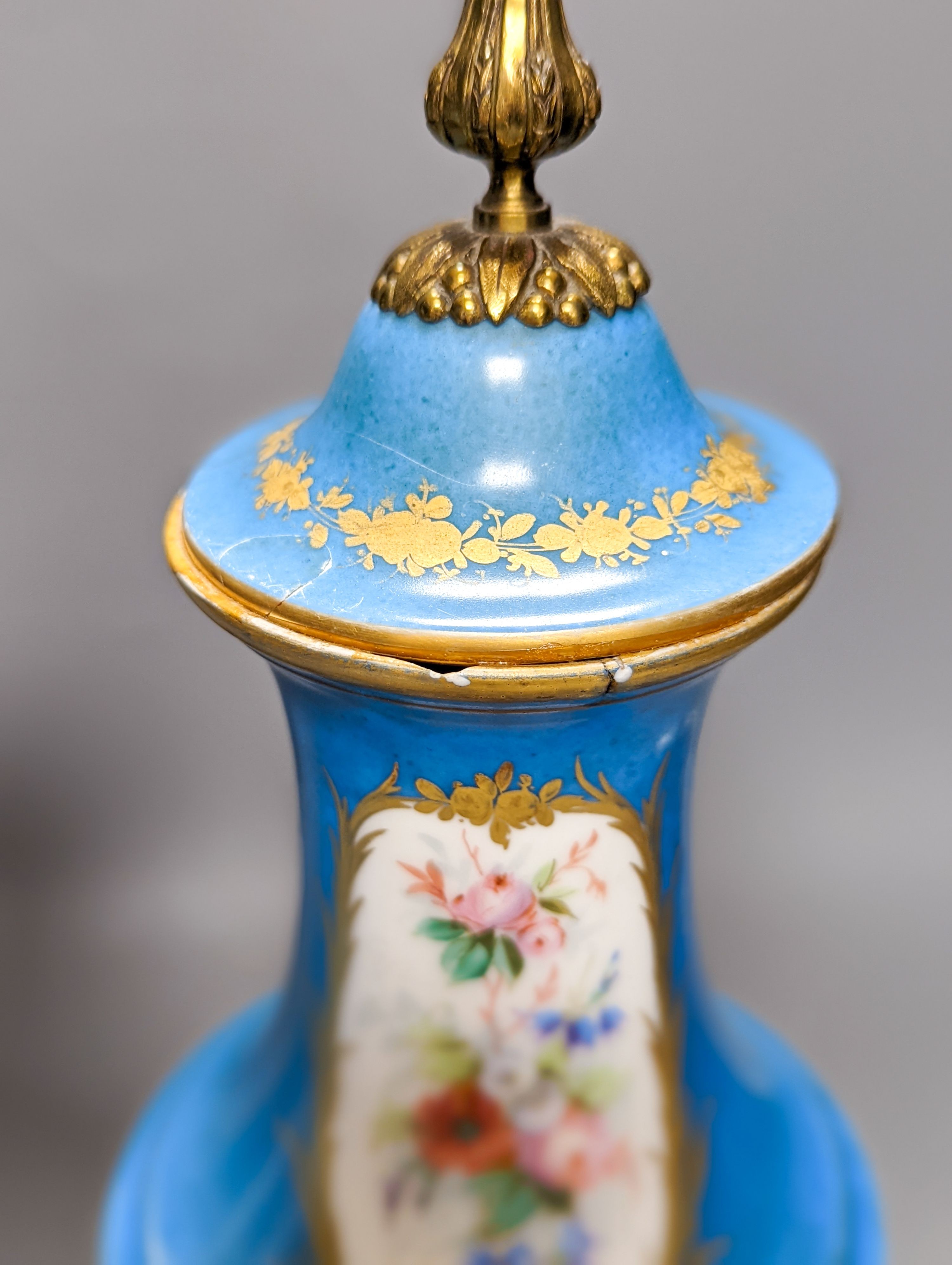 A pair of Sevres style porcelain bleu celeste ground vases and covers, 34cm
